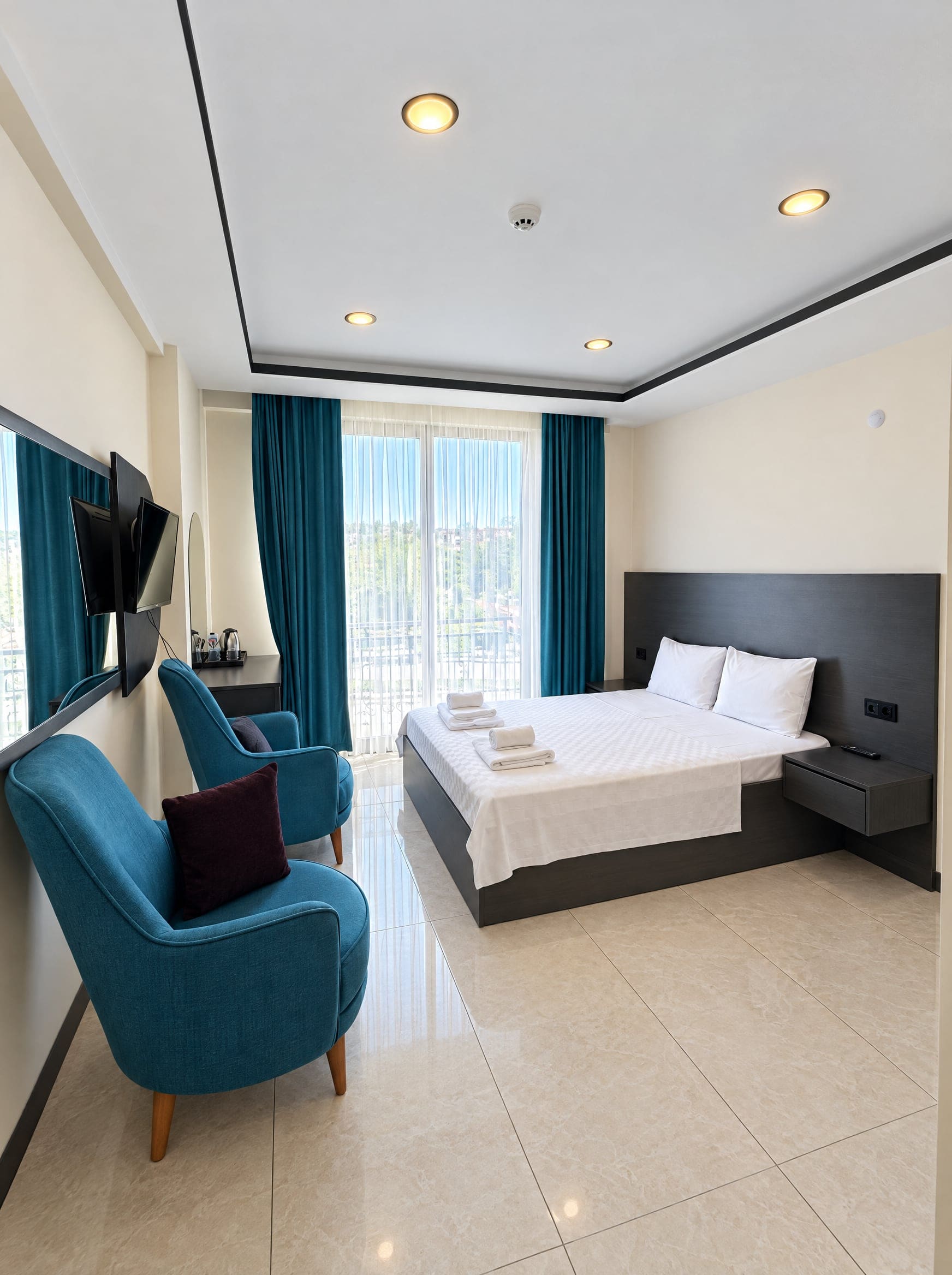 King Suite: master bedroom with balcony and armchairs