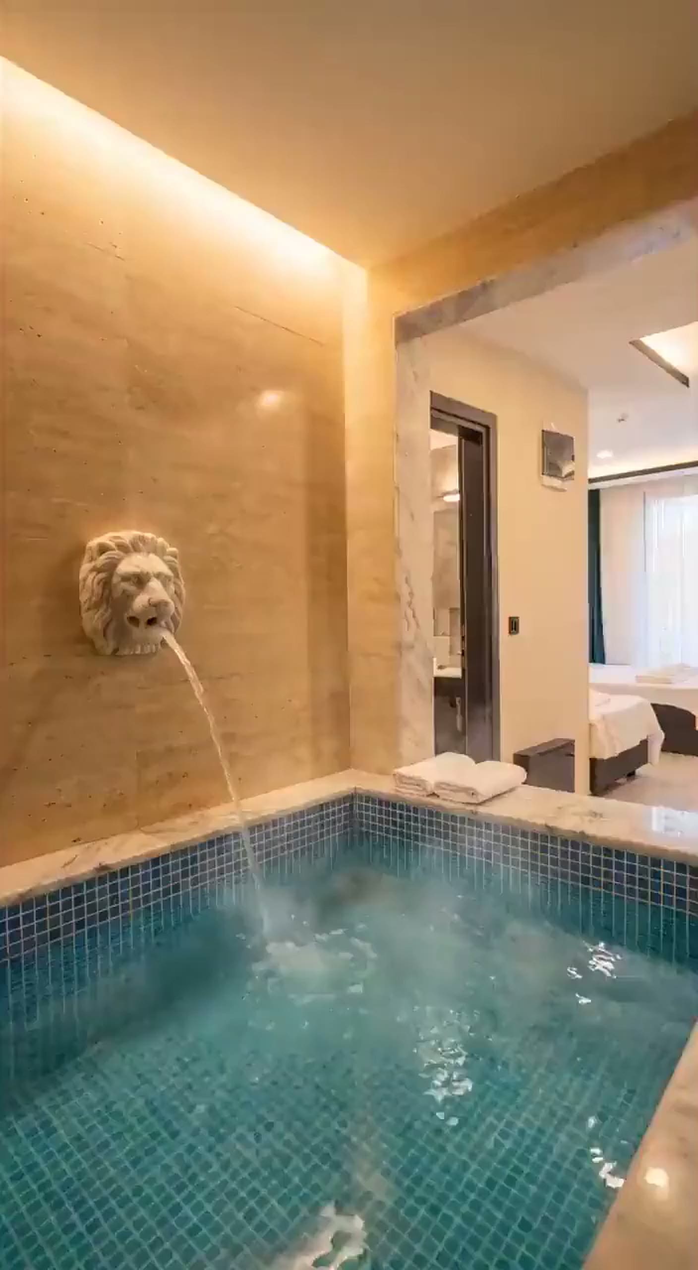 Deluxe Süit'te aslan ağızlı çeşmeden odanın özel termal havuzuna akan su